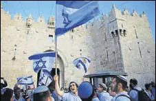  ?? AP FILE ?? Israelis wave national flags outside the Damascus Gate in Jerusalem’s Old City.