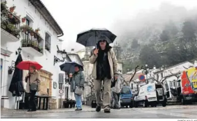  ?? RAMÓN AGUILAR ?? Varias personas en la calle, con lluvia, antes de la pandemia.