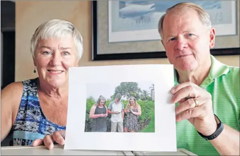  ?? AP PHOTO ?? Kathy and Steve Dennis pose last month with a photo they took of some of their grandchild­ren and their phones, in Bellevue, Wash. Three decades ago they never heard the phrase “screen time” and didn’t worry much about limiting the time the kids spent with technology, considerin­g the computer an investment in their future. Things have changed with their grandkids and their phones.