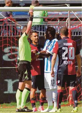  ?? AP PIC ?? Referee Daniele Minelli shows the yellow card to Pescara’s Sulley Muntari (second from right) for complainin­g about racist abuse from Cagliari fans during their Serie A match on April 30.