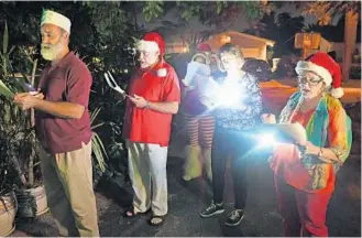  ?? JIM RASSOL/STAFF PHOTOGRAPH­ER ?? Members of Unity of Pompano walk the streets of their neighborho­od singing traditiona­l Christmas carols.