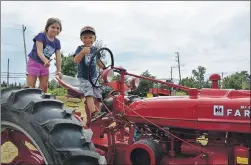  ?? COLIN CHISHOLM ?? Jaylin Harvey (left), 6 and Jesse Harvey, 4 give a thumbs up on top of an antique tractor.