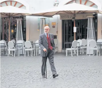  ??  ?? A man walks in front of a closed restaurant in Rome on Wednesday.