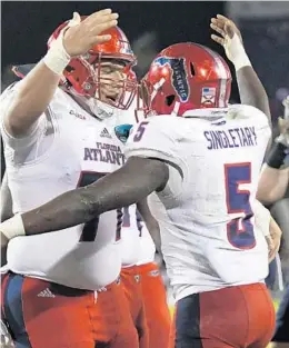  ?? JIM RASSOL/STAFF PHOTOGRAPH­ER ?? Running back Devin Singletary, right, one of four captains honored on Tuesday, celebrates a second-quarter touchdown with offensive lineman Roman Fernandez.