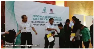  ??  ?? PENYERAHAN sumbangan kepada murid.