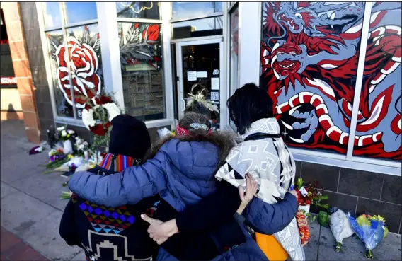  ?? HELEN H. RICHARDSON — THE DENVER POST ?? From left: Jeanette Vizguerra, Elena Klaver and Miranda Encina, who described themselves as healers with a group called Comadres, hug one another in front of a makeshift memorial on Dec. 28, 2021, outside Sol Tribe Custom Tattoo and Body Piercing shop on Broadway. Five were killed and several wounded in a shooting spree that spanned Denver and Lakewood. The FBI and Denver police were called by a reader of the killer’s novels who thought they might be a manifesto.