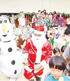  ??  ?? Santa Claus handing out presents to children at Rasa Ria.