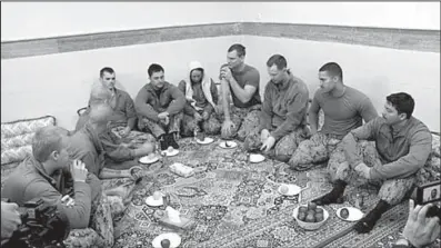  ?? AP/Sepahnews ?? Detained U.S. sailors sit at an undisclose­d location in Iran in this photo released Wednesday by the Iranian Revolution­ary Guard. Among the 10 is a woman shown with a cloth covering her head.