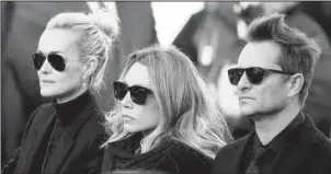  ?? The Associated Press ?? LEGAL DRAMA: French rock star Johnny Hallyday's wife Laeticia, left, his daughter Laura Smet, and son David Hallyday, right, arrive at La Madeleine church on Dec. 9, 2017 for Johnny Hallyday's funeral ceremony in Paris. A court outside Paris on Friday...