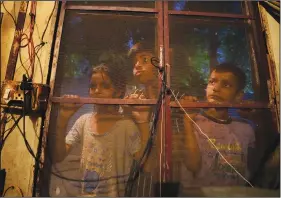  ?? ?? Kashmir’s minority Hindu children look through a netted window June 11 at Purkhoo migrant camp on the outskirts of Jammu.