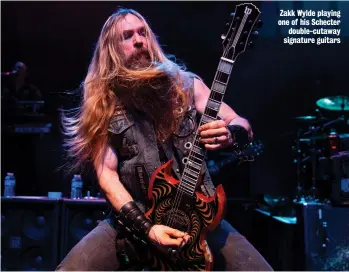  ?? ?? Zakk Wylde playing one of his Schecter double-cutaway signature guitars