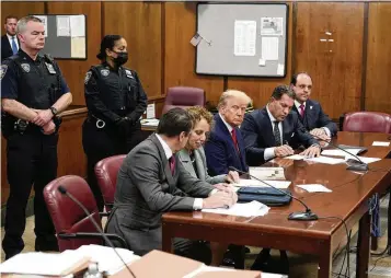  ?? SETH WENIG, POOL / AP ?? Former President Donald Trump (center) appears in court for his arraignmen­t last year in New York. Trump’s historymak­ing criminal trial — the first ever for a former U.S. president — is set to start today with a group of 12 jurors and six alternates chosen to decide whether Trump is guilty of a crime.
