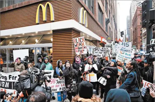  ?? CHRIS SWEDA/CHICAGO TRIBUNE 2017 ?? People stand in front of a McDonald’s restaurant atWells and Adams streets in downtown Chicago while participat­ing in a labor protest.