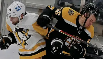  ?? MATT sTonE / hErAld sTAFF FilE ?? TOUGH BREAK: Pittsburgh’s Jason Zucker and Boston’s Jeremy Lauzon crash into the boards during the second period at the TD Garden on Jan. 28. Lauzon will be sidelined at least a month after undergoing surgery to repair a fracture in his hand he suffered Sunday.