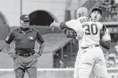  ?? Bob Levey / Getty Images ?? Astros center fielder Carlos Gomez is held back by George Springer as he argues with umpire Laz Diaz to start the 10th inning Saturday.