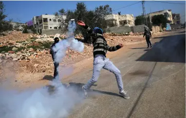  ?? PICTURE: REUTERS ?? STREET FIGHTER: A Palestinia­n protester hurls back a tear gas canister fired by Israeli troops during clashes in the West Bank village of Kofr Qadom near Nablus on Friday.