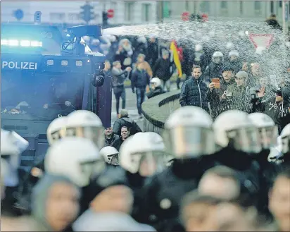  ?? AP PHOTO ?? Police drive back right-wing demonstrat­ors using a water cannon during protests in Cologne, Germany, Saturday.