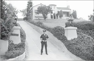  ?? Bettmann Archive/Getty Images ?? AN OFFICER blocks the driveway while police search the Los Feliz home where Leno and Rosemary LaBianca were killed Aug. 10, 1969, the day after the Tate murders across town.