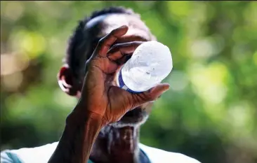  ?? COURTESY OF AMANDA MCCOY ?? Gary Randle, 61, drinks a bottle of cold water brought by an outreach team to his Fort Worth, Texas, homeless camp on June 30. The nation’s persistent housing crisis coupled with increasing­ly hot summers has left the most vulnerable, including the unhoused, at particular risk for getting sick from or dying from the heat.