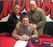  ?? JOHN KAMPF — THE NEWS-HERALD ?? Cameron Niehus, center for the Chardon football team, is all smiles with his parents after signing a national letter of intent on Dec. 20 to play football at John Carroll.