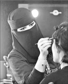  ??  ?? A Saudi makeup artist preps a model backstage.