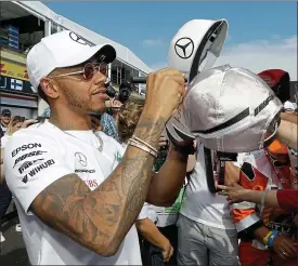  ??  ?? Capping it off: Lewis Hamilton with fans at the first GP at the circuit since 1990