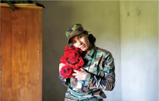 ?? (Reuters) ?? WHERE WILL she return to? Yazidi female fighter Asema Dahir, 21, poses with a teddy bear in a bedroom at a site near the frontline of the fight against Islamic State militants in Nawaran near Mosul, Iraq, in April.
