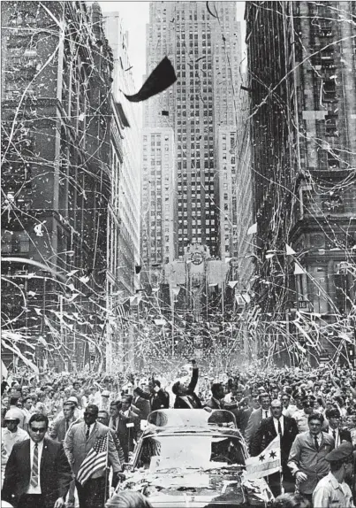  ?? DON CASPER/CHICAGO TRIBUNE ?? Neil Armstrong, center, waves along with Edwin “Buzz” Aldrin, left, and Michael Collins as they ride up LaSalle Street on Aug. 13, 1969.