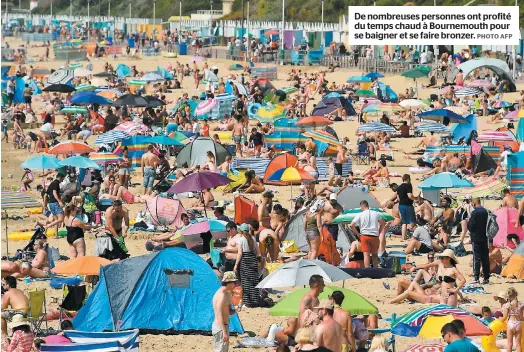  ?? PHOTO AFP ?? De nombreuses personnes ont profité du temps chaud à Bournemout­h pour se baigner et se faire bronzer.