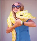  ?? PATRICK TEHAN/ STAFF ?? Alexis Harmon, 16, of St. George, Utah, poses for a snapshot with Daisy, a Burmese python, on opening day Thursday at the Santa Clara County Fair in San Jose.