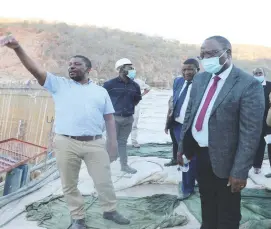  ?? ?? Gwayi-Shangani Dam constructi­on resident engineer Eng Paul Dengu (left) shows the Parliament­ary Portfolio Committee on Economics members the dam wall which is under constructi­on during their tour of Gwayi-Shangani Dam on Tuesday. — Picture by Dennis Mudzamiri