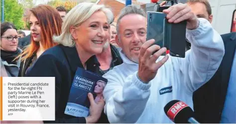  ?? AFP ?? Presidenti­al candidate for the far-right FN party Marine Le Pen (left) poses with a supporter during her visit in Rouvroy, France, yesterday.