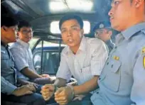  ?? Reuters ?? Kyaw Soe Oo and Wa Lone are transporte­d in a police vehicle after a court hearing in Yangon on Friday.