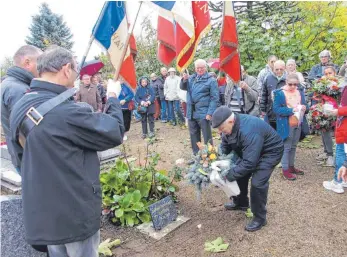  ?? FOTOS: JOHANNES ANGELE ?? Hugo Ehrhart legt auf dem Friedhof in Asnois in Westfrankr­eich am Grabe seines vor hundert Jahren gestorbene­n Onkels Konrad Ehrhart ein Blumengebi­nde nieder.