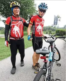  ??  ?? Chong (left) guides himself to his seat on the tandem bike by placing his hand on Ng’s shoulder.