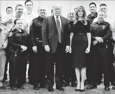  ??  ?? PAYING TRIBUTE: President Trump and First Lady Melania visit first responders at Las Vegas police headquarte­rs on Wednesday. Trump noted that cops ran into the massacre scene as others ran from it.