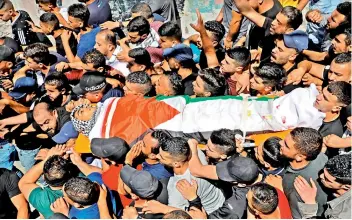  ?? — AFP ?? Palestinia­ns carry the body of Obaida Jawabreh, killed on Monday during clashes with Israeli soldiers, at his funeral in al-Aroub refugee camp, north of Hebron city in the the occupied West Wank, on Tuesday.