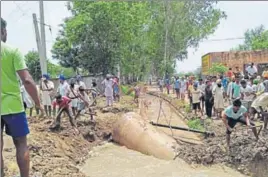  ??  ?? Residents of Jodhpur in Barnala district trying to stop water of an overflowin­g channel from entering their locality on Saturday. HT PHOTO