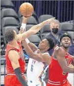  ?? /SUE OGROCKI / AP ?? Oklahoma City Thunder guard Hamidou Diallo shoots between Chicago Bulls forward Daniel Gafford, left, and forward Patrick Williams.