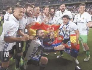  ?? EFE ?? Los jugadores del Real Madrid celebran la consecució­n del título de liga a la finalizaci­ón del encuentro correspond­iente a la última jornada de Primera División, que han disputado frente al Málaga en el estadio de la Rosaleda, en Málaga.