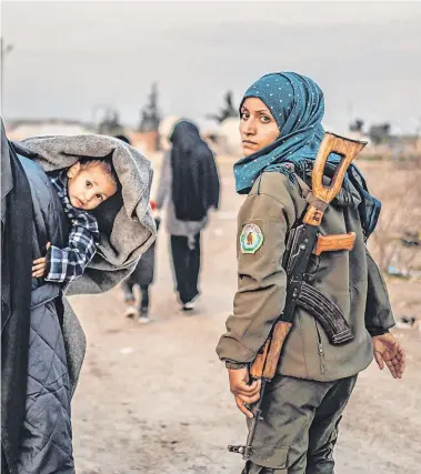  ?? PHOTO: AFP/GETTY ?? Under guard: Veiled women, wives of fighters and members of Isil, are guarded by a woman fighter of the Syrian Democratic Forces at the al-Hol refugee camp in north-eastern Syria.