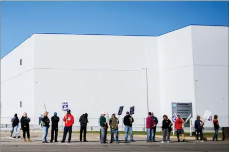  ?? JAKE MAY — THE FLINT JOURNAL VIA AP ?? General Motors’ Flint Assembly Plant employees line the street with picket signs during the nationwide UAW strike against General Motors on Monday in Flint, Mich.