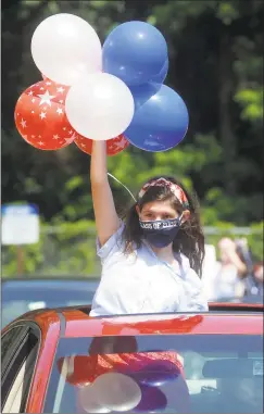  ??  ?? Madison Gassel waves balloons as she and other volunteers take part in Independen­ce Day drive-by parade for the residents of Jewish Senior Services and Hollander House in Bridgeport on Thursday.