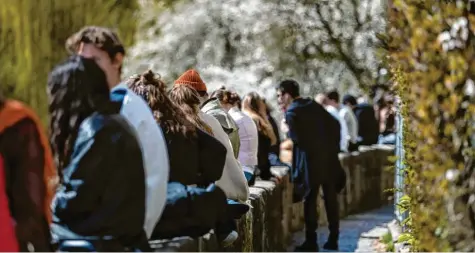  ?? Foto: dpa/picture alliance ?? Ein BIld wie aus längst vergangene­n Zeiten: Zahlreiche Menschen sitzen in Tübingen bei frühlingsh­aften Temperatur­en zusammen auf der Neckarmaue­r und genießen das Wetter. Zahlreiche Städte in Bayern wollen auch derartige Öffnungen erproben. Während Ingolstadt für das Modellproj­ekt bereits aus dem Rennen ist, rechnet sich Neuburg noch Chancen aus.