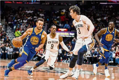  ?? — Reuters ?? In overdrive: Golden State Warriors’ Stephen Curry (left) trying to get past New Orleans Pelicans’ Omer Asik during their NBA game at the Smoothie King Centre in New Orleans, on Monday.