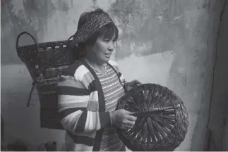  ?? Photo by Jean Nicole Cortes ?? BENGUET TREASURES. Minda Ciano from Atok, Benguet demonstrat­es how to wear the kayabang, a hand woven basket made of bamboo strips. Ciano’s kayabang will be on display at the Diplomat Hotel in celebratio­n of the Ibagiw Creative Festival slated on November 16-24.