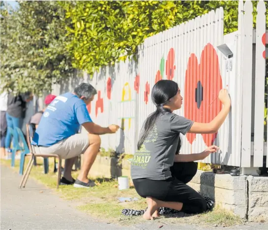  ?? Photo / Paul Taylor ?? Aryn Price from Flaxmere paints poppies on a neighbourh­ood fence in honour of Anzac Day.