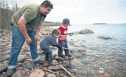  ?? PAT KANE PHOTOS ?? Children play with a toy boat on the shore of Great Slave Lake, part of the 26,300-square-kilometre Thaidene Nëné protected area.