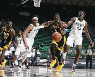  ?? Rod Aydelotte / Waco Tribune-Herald ?? Baylor guard Jordan Turner (5) and teammate Jonathan Tchamwa Tchatchoua (23) fight with Arkansas-Pine Bluff forward Markedric Bell (3) for a rebound. The Bears improved to 6-0.