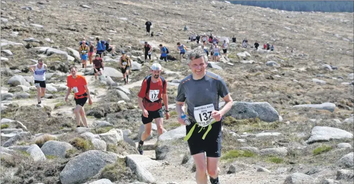  ?? 01_B21race08 ?? Andrew Walsh at the front of a long line of runners on the hill.